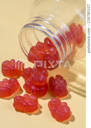 Jelly gummy bears in a jar, fruit vitamins on bright background, food supplements.Orange vitamins in a jar Jelly gummy bears in a jar, fruit vitamins on bright background, food supplements.Orange vitamins in a jar 138780327
