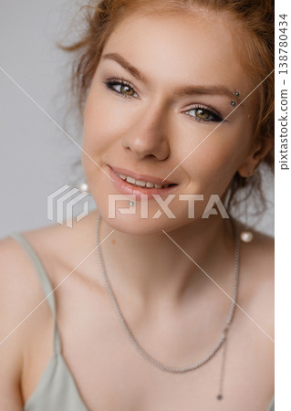 Close up portrait of smiling young Caucasian redhead woman with green eyes, white background 138780434