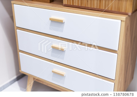 Simple wood cabinet. Contemporary minimalist wooden storage unit with brass knobs and soft lighting 138780678