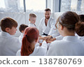 Instructor guiding children during martial arts lesson with cheerful faces and focused expressions 138780769