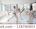 Children practicing karate with bokken under instructor guidance 138780803