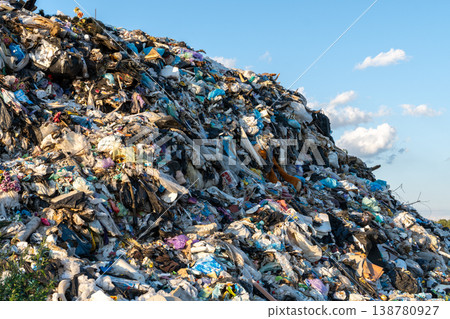 People or machines may be working in the landfill as they manage waste materials and collect refuse on a sunny day in the city 138780927