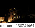 Night view of illuminated historic stone building in Mostar old town, with warm window lights and fortress walls against a dark sky, creating a calm and atmospheric Balkan city scene 138784064