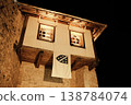 Traditional stone house with wooden details is illuminated at night in Mostar. Warm light from windows emphasizes historic Balkan architecture and calm evening mood 138784074
