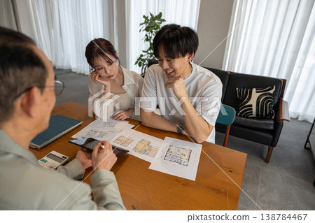 一對年輕夫婦正在諮詢承包商有關建房事宜。 138784467