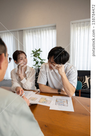 A young couple is consulting with a contractor about building a house. 138784472