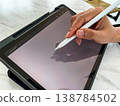 Close up of hand using stylus on tablet screen, representing digital drawing, remote work, creative design, technology workflow, modern lifestyle, and productivity in a connected digital environment 138784502