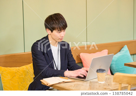 A man and a woman working on their laptops in a cafe-style co-working space. A man and a woman working on their laptops in a cafe-style co-working space. 138785042