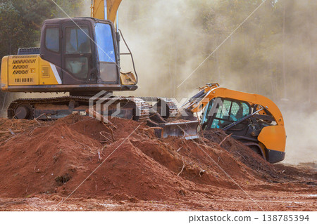 Heavy machinery clears land at construction site near wooded area 138785394