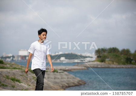 A male student walking along the coast A male student walking along the coast 138785707
