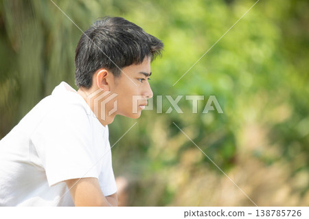 一位神情莊重的高中男生，陷入沉思（側面像）。 138785726