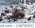 Chocolate dessert drizzled with cream in a splash on a textured surface after being cut 138785851