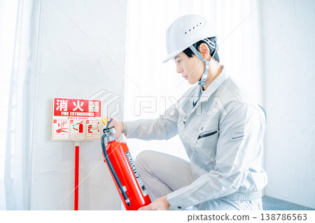 一名身穿工作服的男子正在檢查消防安全設備。 138786563