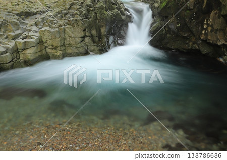Emerald green stream flows through the valley. Emerald green stream flows through the valley. 138786686