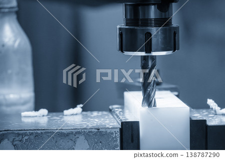 Precision NC milling of a white nylon material part using a flat nose end mill tool in a modern industrial setting. 138787290