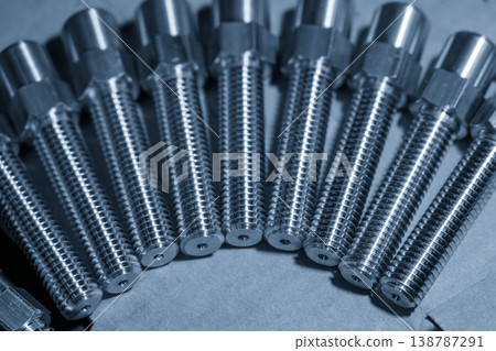 A creative arrangement of metal screws organized in a half-circle shape on a blue-toned industrial background. 138787291