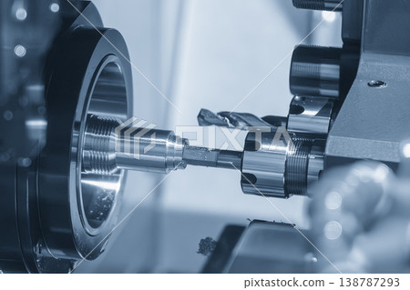 Advanced multi-tasking CNC lathe machine performing a precision hole cutting process on a metal shaft. Advanced multi-tasking CNC lathe machine performing a precision hole cutting process on a metal shaft. 138787293