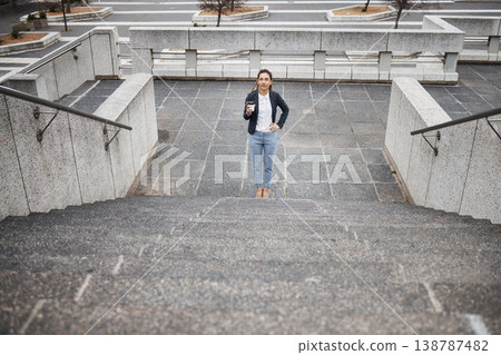 Thinking, travel and business woman on stairs with success mindset, future growth and progress in city. Professional goals, ideas and female person with coffee for career, work and job in urban town 138787482