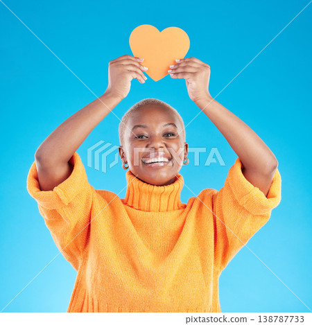 Portrait, emoji and heart with a black woman on blue background in studio for health or wellness. Smile, love and social media with a happy young person looking excited for romance or valentines day 138787733