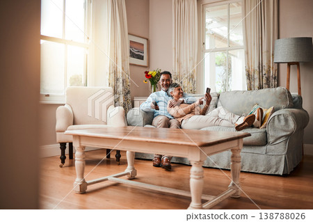 Senior couple, sofa and relax with watching tv, phone and social media with hug, care and bonding in home. Mature man, woman and happy together on living room couch with movie, web chat and embrace Senior couple, sofa and relax with watching tv, phone and social media with hug, care and bonding in home. Mature man, woman and happy together on living room couch with movie, web chat and embrace 138788026