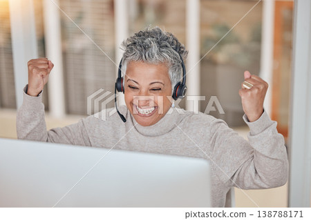 Computer, success and a senior woman in a call center for customer service, support or motivation. Contact, headset and a happy female consultant in celebration at a desk in a professional crm office Computer, success and a senior woman in a call center for customer service, support or motivation. Contact, headset and a happy female consultant in celebration at a desk in a professional crm office 138788171