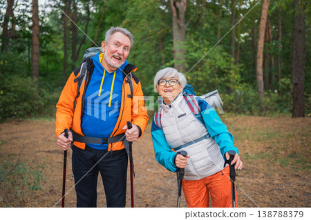 Hiking tourism adventure. Senior couple man woman enjoying outdoor recreation hiking in forest. Happy old people backpackers hikers enjoy walking hike trekking tourism active vacation beauty of nature Hiking tourism adventure. Senior couple man woman enjoying outdoor recreation hiking in forest. Happy old people backpackers hikers enjoy walking hike trekking tourism active vacation beauty of nature 138788379
