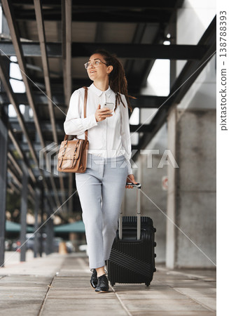 Phone, travel and suitcase with a business woman in an airport parking lot walking outdoor in the city. Mobile, luggage and commute with a young corporate professional on an international work trip 138788393