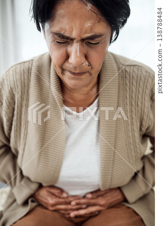 Stomach pain, sick or illness with a senior woman in her home, holding her belly in discomfort. Healthcare, medical and emergency with an elderly pensioner feeling uncomfortable after food poisoning Stomach pain, sick or illness with a senior woman in her home, holding her belly in discomfort. Healthcare, medical and emergency with an elderly pensioner feeling uncomfortable after food poisoning 138788484