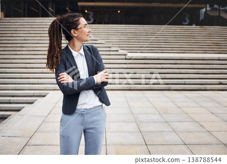 Thinking, city and business woman on stairs with happy mindset for morning commute, journey and travel. Professional, ideas and female person with crossed arms for career, work and job in urban town 138788544