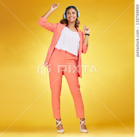 Woman, headphones and happy dance to music in studio for fashion, freedom and audio energy on yellow background. Indian model, style and dancing to celebration, listening to radio and streaming sound 138788660