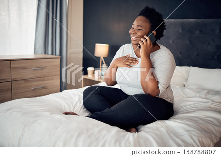 Phone call, happy and black woman on bed in home, talking and communication in the morning. Smartphone, conversation and African plus size person smile for discussion, chat and speaking in bedroom Phone call, happy and black woman on bed in home, talking and communication in the morning. Smartphone, conversation and African plus size person smile for discussion, chat and speaking in bedroom 138788807