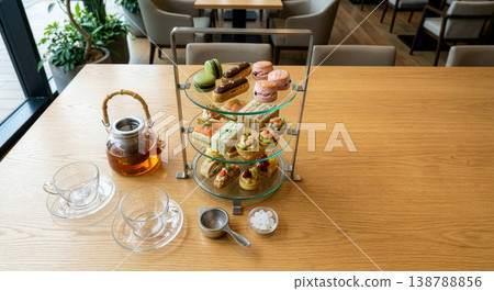 A luxurious afternoon tea set to enjoy at a cafe or hotel: an image of a three-tiered stand and tea. 138788856