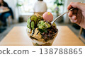 A close-up of hands eating a matcha parfait at a cafe; an image of enjoying a luxurious, modern Japanese sweet. 138788865