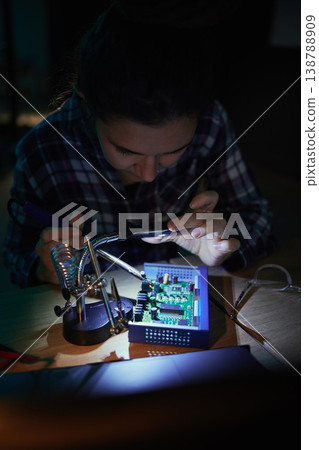 Woman, computer motherboard and night with soldering iron, manufacturing and microchip for it development. Information technology, circuit board and electronics for engineering, hardware and system 138788909