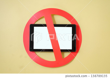 Mobile phone with prohibition sign on color background. Mobile phone with prohibition sign on color background. 138789135