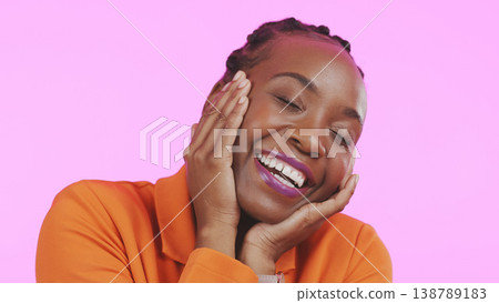 Woman, hands and happy on face with makeup, smile and excited with playful expression by pink background. Black person, emoji or self love for cosmetic, lipstick or beauty aesthetic and studio mockup 138789183
