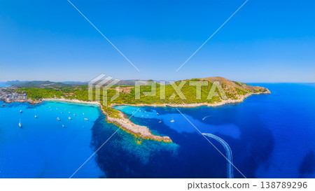 Aerial view of Cala Agulla beach and turquoise bay with boats in Mallorca. Aerial view of Cala Agulla beach and turquoise bay with boats in Mallorca. 138789296