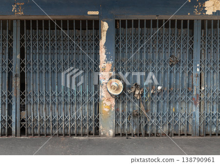 Draped in peeling blue paint and the patina of time, this classic metal folding door captures the soul of traditional urban life. Its intricate lattice of diamond-shaped steel allows the gate to fold Draped in peeling blue paint and the patina of time, this classic metal folding door captures the soul of traditional urban life. Its intricate lattice of diamond-shaped steel allows the gate to fold 138790961