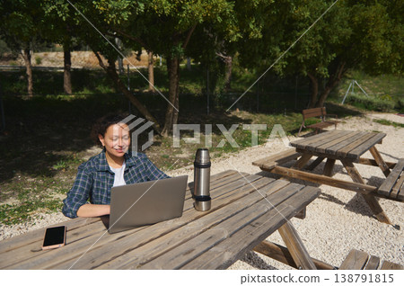 Woman working remotely on laptop in park with copy space Woman working remotely on laptop in park with copy space 138791815