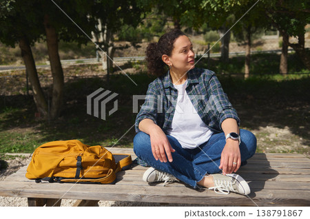 Back view of woman sitting outdoors enjoying nature 138791867