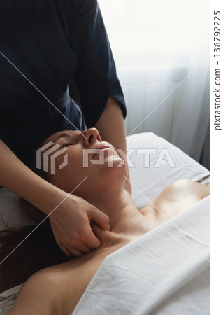 Woman receiving relaxing professional neck and shoulder massage therapy. Client enjoying rejuvenating massage treatment in tranquil spa environment Woman receiving relaxing professional neck and shoulder massage therapy. Client enjoying rejuvenating massage treatment in tranquil spa environment 138792225
