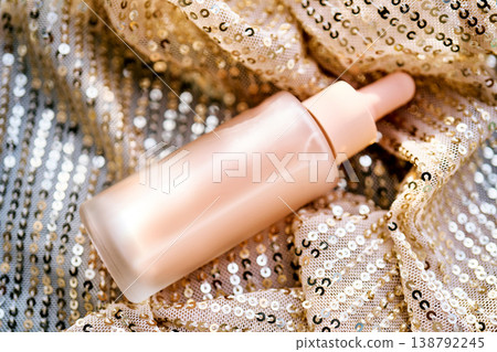 Luxury skincare serum bottle on golden sequins Luxury skincare serum bottle on golden sequins 138792245