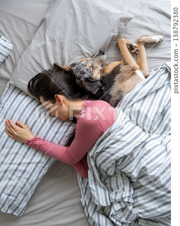 top view of sleeping woman and dog in bed. girl and pet sleep comfortably together and cuddle.  138792380