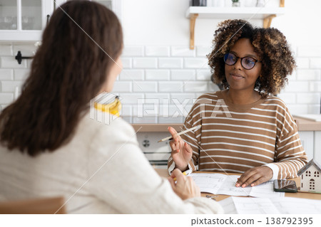 confident curly haired woman with curly dark hair, designer or realtor, shows mock up house. confident curly haired woman with curly dark hair, designer or realtor, shows mock up house. 138792395