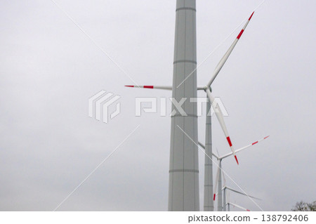 wind turbines in field rotate their blades to generate energy. windmill on spacious green field. wind turbines in field rotate their blades to generate energy. windmill on spacious green field. 138792406