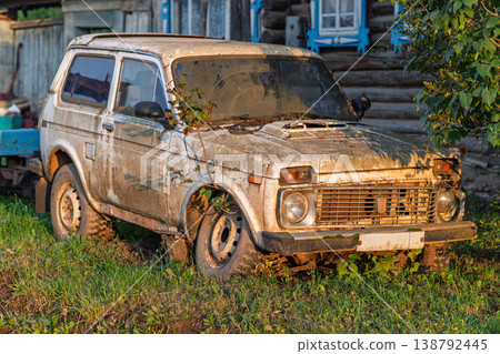 Vintage SUV with faded paint illuminated by evening golden light and extensive shadows Vintage SUV with faded paint illuminated by evening golden light and extensive shadows 138792445