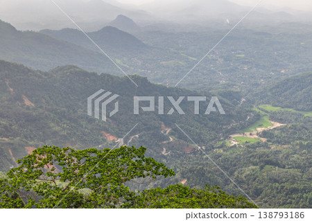 View from Ambuluwawa Tower, multi-religious temple complex located in Gampola, in Sri Lanka. Panoramic view of mist-shrouded green mountains and a lush valley landscape 138793186