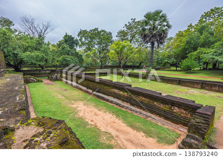 Ancient Royal Palace Ruins in Polonnaruwa, Sri Lanka. Ancient architectural remains surrounded by lush green landscapes under a cloudy sky, showcasing historical heritage 138793240