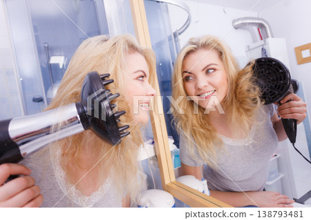 Woman doing curls with hairdryer diffuser Woman doing curls with hairdryer diffuser 138793481