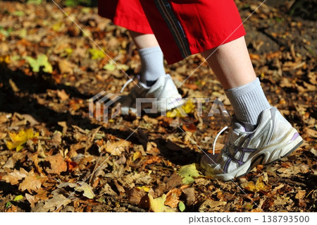 Woman walking cross country trail in autumn forest Woman walking cross country trail in autumn forest 138793500